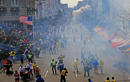 People react as an explosion goes off near the finish line of the 2013 Boston Marathon in Boston, Monday, April 15, 2013. Two explosions went off at the Boston Marathon finish line on Monday, sending authorities out on the course to carry off the injured while the stragglers were rerouted away from the smoking site of the blasts. (AP)