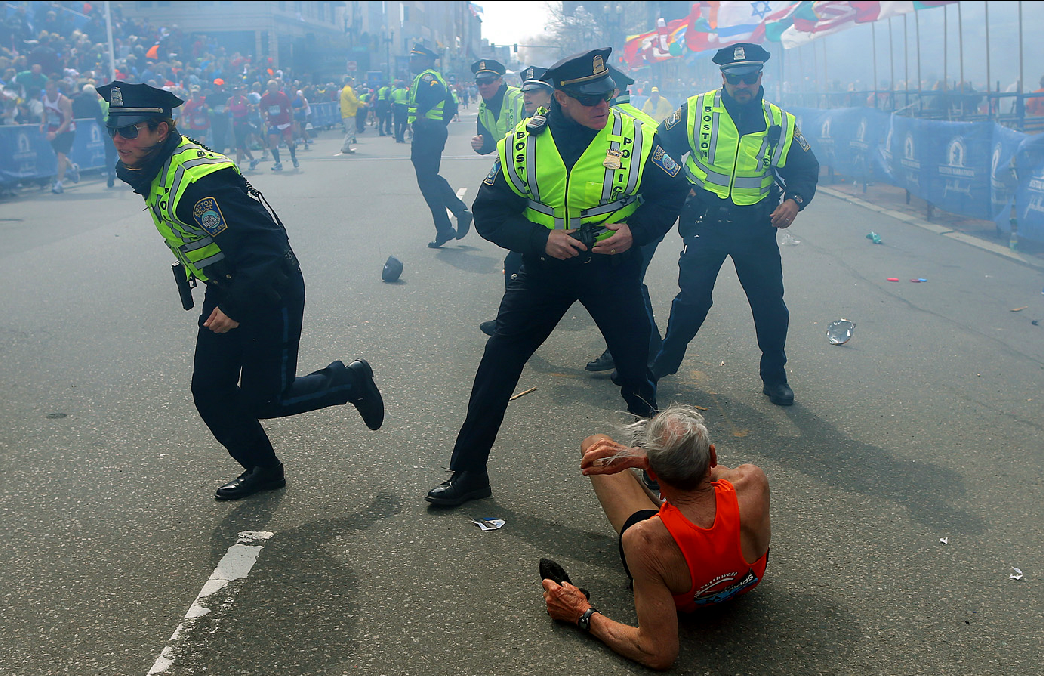 Bill Iffrig, 78, lies on the ground as police officers react to a second explosion at the finish line of the Boston Marathon in Boston, Monday, April 15, 2013. Iffrig, of Lake Stevens, Wash., was running his third Boston Marathon and near the finish line when he was knocked down by one of two bomb blasts. (AP)