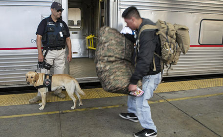 Amtrak Explosive Detection K-9 officer  Kenneth Wolf and his dog Teddy ask a passenger to inspect his luggage before boarding a departing train at Union Station in Los Angeles Monday, April 15, 2013. The city increased security following bomb explosions in Boston that killed two people and injured more than 80 near the crowded finish line of the Boston Marathon. (AP)