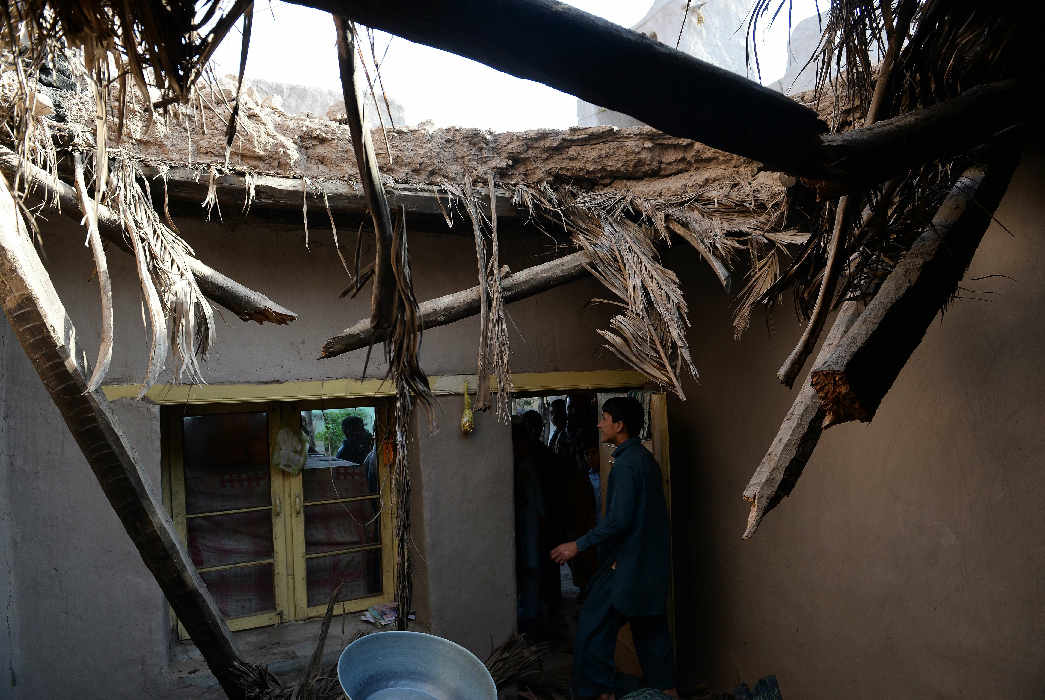 An Afghan family stands inside their home damaged by a powerful earthquake in Charbagh village in Nangarhar province on April 24, 2013. Seven people were killed, dozens injured and many homes destroyed when a powerful earthquake struck eastern Afghanistan on Wednesday, officials said. (AFP)