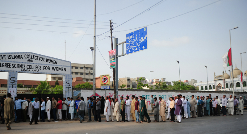 Pakistani voters queue for their turn to cast their vote outside a polling station in Karachi on May 11, 2013. (AFP)