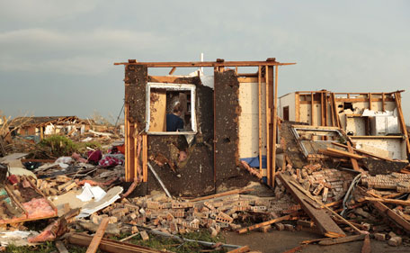 Dana Ulepich searches inside a room left standing at the back of her house destroyed after a powerful tornado ripped through the area on May 20, 2013 in Moore, Oklahoma. The tornado, reported to be at least EF4 strength and two miles wide, touched down in the Oklahoma City area on Monday killing at least 51 people.   (AFP)