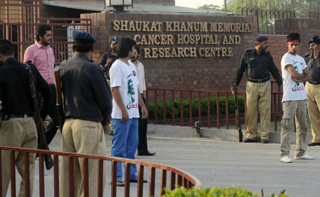 Pakistani police and several Pakistan Tehreek-e-Insaaf (PTI) activists keep watch outside the Shaukat Khanum Memorial Hospital in the eastern city of Lahore on May 22, 2013 where Pakistani politician Imran Khan was being treated. Khan left hospital on May 22, two weeks after breaking bones in his back in a fall at an election rally, a hospital spokesman said. The 60-year-old was ordered to remain immobile in bed after he fractured vertebrae and a rib in a dramatic tumble just days before the May 11 general election, where his Pakistan Tehreek-e-Insaaf party made a major breakthrough. (AFP)