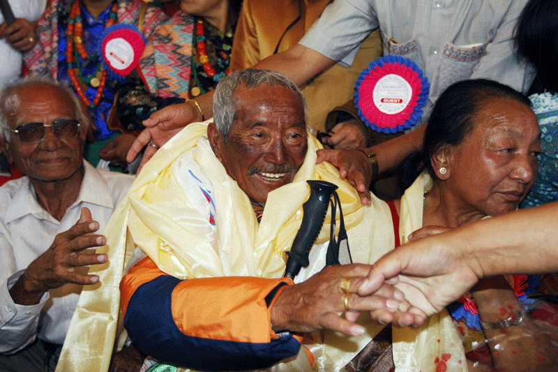 In this May 31, 2008 file photo, Min Bahadur Sherchan, centre, who became the oldest person to climb Mount Everest on May 25, 2008 shakes hands on his arrival in Katmandu, Nepal (AP)