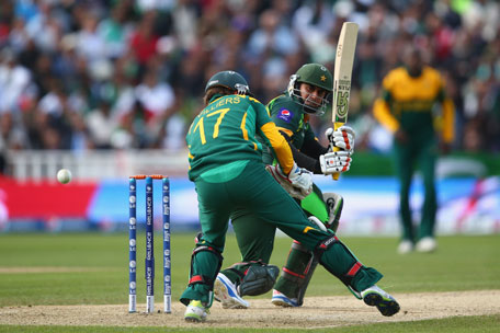 Nasir Jamshed (right) of Pakistan sweeps a ball past AB de Villiers of South Africa during the ICC Champions Trophy Group B match at Edgbaston on June 10, 2013 in Birmingham, England. (GETTY)