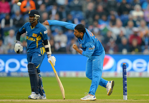 India's Mahendra Sing Dhoni (R) bowls during the 2013 ICC Champions Trophy semi-final cricket match between India and Sri Lanka at the Cardiff Wales Stadium in Cardiff, south Wales, on June 20, 2013. (AFP)