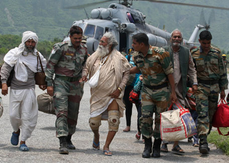 In this handout photograph released by the Indian Ministry of Defence on June 23, 2013, Indian defence personnel assist rescued civilians from the Gangotri area after being flown to safety on board an Indian Air Force Mi-17 transport helicopter at Dharasu in Uttarakhand state on June 22, 2013. Bad weather hampered rescue operations June 23 in rain-ravaged northern India where the death toll from landslides and flash floods was likely to rise up to 1,000 with thousands of pilgrims and tourists still stranded in remote mountains without food or water for days. (AFP)