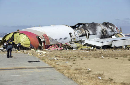 This image released by the National Transportation Safety Board Sunday, July 7, 2013, shows NTSB workers near the Boeing 777 Asiana Airlines Flight 214 aircraft. The Asiana flight crashed upon landing Saturday, July 6, at San Francisco International Airport, and two of the 307 passengers aboard were killed. (AP)