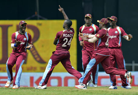 West Indies bowler Kemar Roach (centre) celebrates with teammates after bowling out Sri Lanka's Dinesh Chandimal during the fifth match of the Tri-series at the Queen's Park Oval in Port of Spain on July 7, 2013. (AFP)