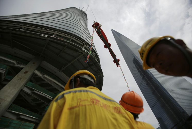 The last piece of the tower is lifted to put in place at the top of the Shanghai Tower during the topping off ceremony in Shanghai, China, Saturday (AP)