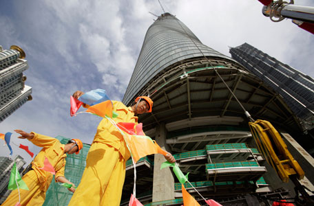 The last piece of the tower is lifted to put in place at the top of the Shanghai Tower during the topping off ceremony in Shanghai, China, Saturday, Aug. 3, 2013. The Shanghai Tower is set to become the tallest building in China which is planned to be complete in 2014. (AP)