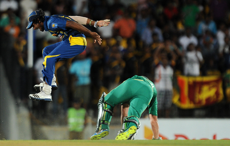 Sri Lankan cricketer Kusal Perera (L) leaps into the air after he dismissed South African batsman AB de Villiers during the second Twenty20 cricket match between Sri Lanka and South Africa at the Suriyawewa Mahinda Rajapakse International Cricket Stadium in the southern district of Hambantota on August 4,2013. (AFP)