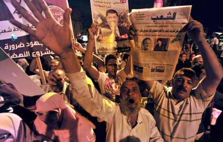 Muslim Brotherhood supporters shout slogans as they wave portraits of Egypt's ousted president Mohamed Morsi during a demonstration in the port city of Alexandria on August 13, 2013, against the former leader's overthrow by the military. The Brotherhood is demanding the release of Morsi and other top party figures who were detained by the military on July 3. (AFP)