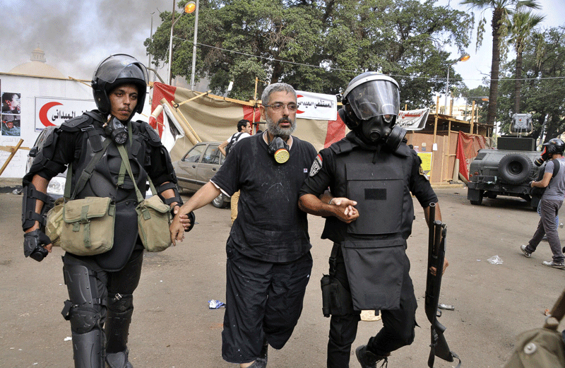 Egyptian riot police forces evacuate supporters of Egypt's ousted president Mohamed Morsi from a camp in Cairo's Al Nahda square on August 14.  (AFP)
