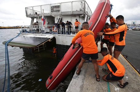 Philippine Coast Guard divers transfer a rubber boat as they prepare to be deployed to augment rescue operations in Cebu from their headquarters in Manila, Philippines on Saturday, Aug. 17, 2013. A ferry with more than 800 people aboard sank near the central Philippine port of Cebu after colliding with a cargo vessel, killing at least 28 people. Hundreds have been rescued but more than 200 are still missing, the coast guard said Saturday. (AP)