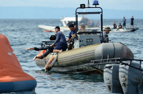 Philippine Navy personnel retrieve a dead body from the sea believed to be one of the passengers from the sunken ferry St. Thomas Aquinas on August 17, 2013 after it collided with a cargo ship the night before off the town of Talisay near the Philippines' second largest city of Cebu. Philippine rescuers searched on August 17 for more than 200 people missing after the ferry collided with the cargo ship in thick darkness and sank almost instantly, with 26 already confirmed dead. (AFP)