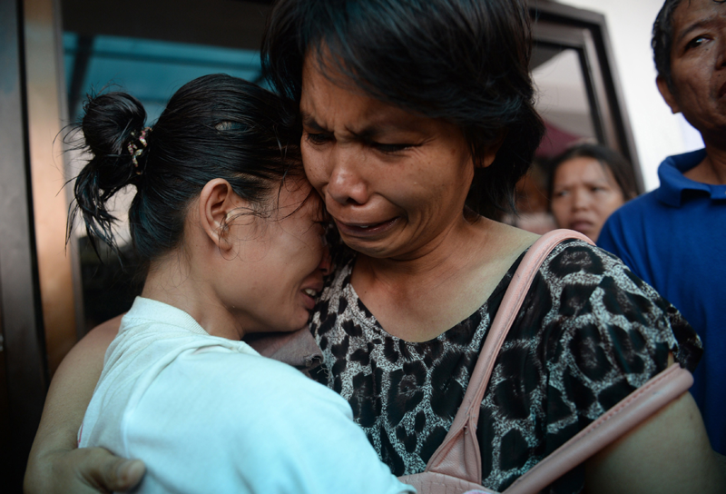 A survivor (L) reacts as she is reunited with a relative outside the ferry company's office in Cebu City, central Philippines on August 17, 2013 after a ferry collided with a cargo ship and sank on August 16. Stormy weather forced Philippine rescuers to suspend a search on August 17 for 171 people missing after a crowded ferry collided with a cargo ship and quickly sank, with 31 others confirmed dead.  (AFP)