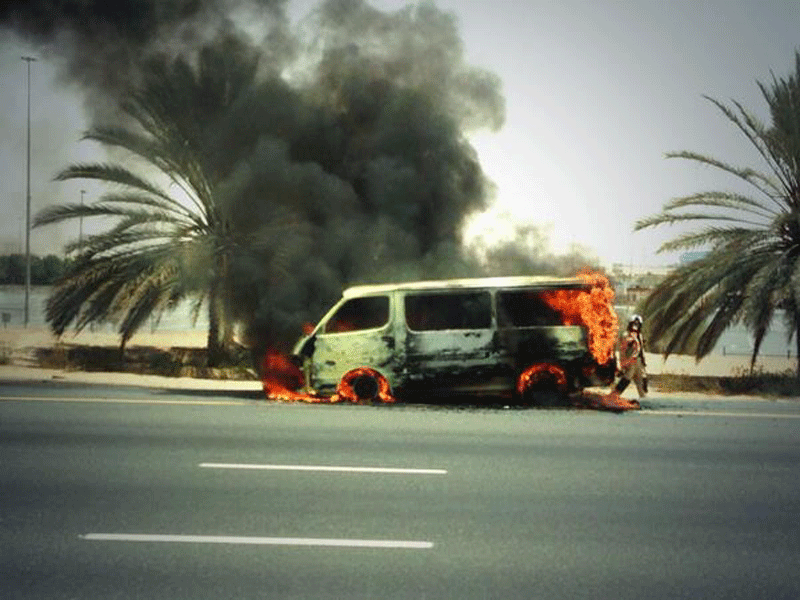 The minibus on fire near Global Village on Sheikh Mohammed bin Zayed Road on Thursday afternoon.
