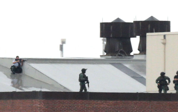 Snipers take their positions on the roof of a building at the Navy Yard complex where a shooting took place early this morning September 16, 2013 in Washington, DC. Early reports indicate that several people may have been shot, and police are still trying to determine the number of suspects involved in the shooting.   (Getty Images)