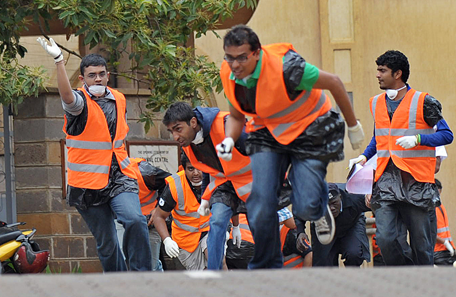 Volunteers from the asian-community run for cover, after hearing a volley of gunshots at the scene of a siegeof an upmarket shopping mall by al-shebab, Somalia based al-Qaeda linked terror network. Atleast 69 are confirmed dead and 63 recorded in an ongoing hostile take-over of the prestigious  Westgate shopping mall that has been claimed by the shebab whose operatives have been engaged in heavy exchanges with a combined force of Kenya's defence forces an elite police units. (AFP)