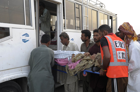 Injured Pakistani earthquake survivors are shifted by relatives to an ambulance in the devastated district of Awaran on September 28, 2013. A powerful 6.8-magnitude earthquake hit southwest Pakistan, killing at least 22 people in a region already devastated by a tremor which left more than 300 people dead this week, local officials said. (AFP)