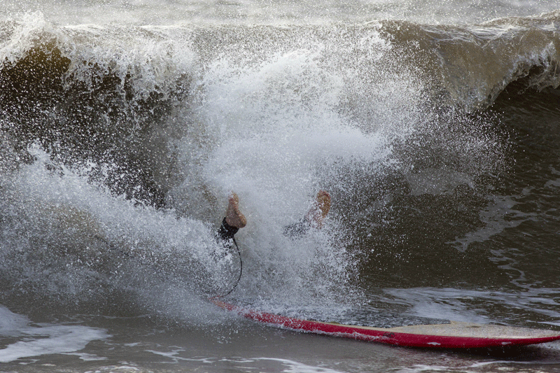 A surfer falls off a wave at Charmouth, in Dorset, southern England on October 28 after a storm struck. Britain faced travel chaos on October 28 and over 200,000 homes were without power as one of the worst storms in years battered southern England, sweeping at least one person out to sea.  (AFP)