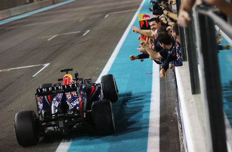 Sebastian Vettel of Germany and Infiniti Red Bull Racing celebrates in front of team mates as he crosses the finishing line to win the Abu Dhabi Formula One Grand Prix at the Yas Marina Circuit on November 3, 2013 in UAE. (GETTY)