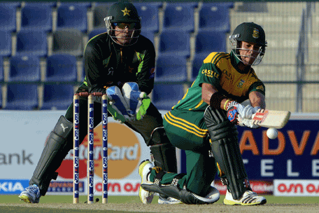 South African batsman JP Duminy (R) sweeps a shot as Pakistani wicket keeper Umar Akmal (L) looks on during the third day-night international in Sheikh Zayed Cricket Stadium in Abu Dhabi on Novemver 6, 2013. South African captain AB de Villiers won the toss and decided to bat in the first. The five-match series is tied at 1-1. (AFP)