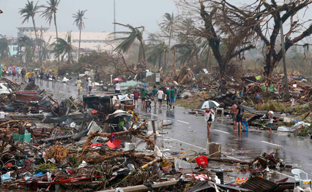 Residents walk on a road littered with debris after Super Typhoon Haiyan battered Tacloban city in central Philippines November 10, 2013. Haiyan, one of the most powerful storms ever recorded, killed at least 10,000 people in the central Philippines province of Leyte, a senior police official said on Sunday, with coastal towns and the regional capital devastated by huge waves. Super typhoon Haiyan destroyed about 70 to 80 percent of the area in its path as it tore through the province on Friday, said chief superintendent Elmer Soria, a regional police director.   (REUTERS)