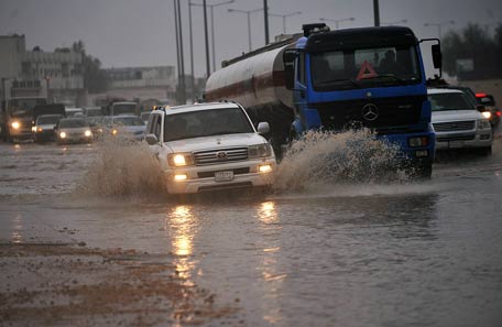 Vehicles drive despite of the water in a flooded street of the Saudi capital Riyadh. (AFP)