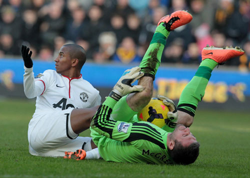 Manchester United's English midfielder Ashley Young (L) looks on after a heavy tackle with Hull City's Scottish goalkeeper Alan McGregor during the English Premier League football match between Hull City and Manchester United at The KC Stadium in Hull on December 26, 2013.  Manchester United won 3-2. (AFP)
