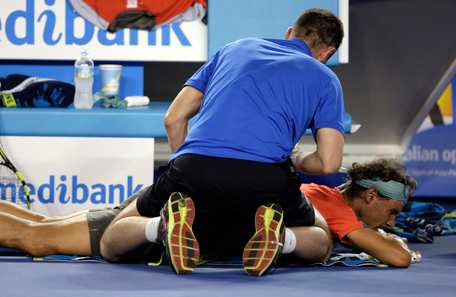 Rafael Nadal of Spain receives a medical treatment to his back as he plays Stanislas Wawrinka of Switzerland during the men's singles final at the Australian Open tennis championship in Melbourne, Australia, Sunday, Jan. 26, 2014.(AP)
