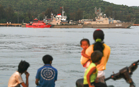 Residents look at ships  anchored at a local naval base at Phu Quoc island, in the waters of southern Vietnam, where a Malaysian Airlines jet was presumed lost on March 8, 2014. Vietnam said its search planes spotted oil slicks in the sea near where a Malaysia Airlines jet with 239 people mysteriously vanished and was presumed lost. (AFP)