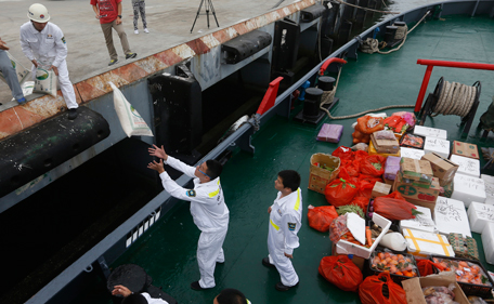 Staff members from the China Maritime Safety Administration (MSA) load equipments and supplies onto the MSA ship Haixun-31 during a brief stop in Sanya in southern China's Hainan province Sunday March 9, 2014. The ship is expected to join an ongoing search for the missing Malaysian airline passenger plane that vanished on Saturday.  (AP)