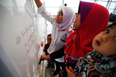 Women leave messages of support and hope for the passengers of the missing Malaysia Airlines flight MH370 at the Kuala Lumpur International Airport March 11, 2014. The Malaysian military believes an airliner missing for almost four days with 239 people on board flew for more than an hour after vanishing from air traffic control screens, changing course and travelling west over the Strait of Malacca, a senior military source said.  (REUTERS)