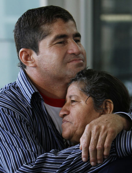 Sea survivor Jose Salvador Alvarenga, center, embraces his mother Maria Julia, after they arrive at the airport in Mexico City, Friday, March 14, 2014. (AP)
