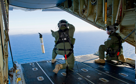 In this photo provided by the Australia Defence Department March 20, 2014, Royal Australian Air Force Loadmasters Sgt. Adam Roberts, left, and Flight Sgt. John Mancey, launch a Self Locating Data Marker Buoy from a C-130J Hercules aircraft in the southern Indian Ocean as part of the Australian Defence Force's assistance to the search for Malaysia Airlines flight MH370. (AP)