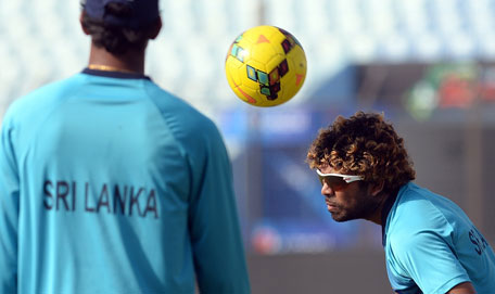 Sri Lanka cricketer Lasith Malinga (right) plays football during a warm-up game at a training session during the ICC World Twenty20 tournament at the Zahur Ahmed Chowdhury Stadium in Chittagong on March 30, 2014. (AFP)