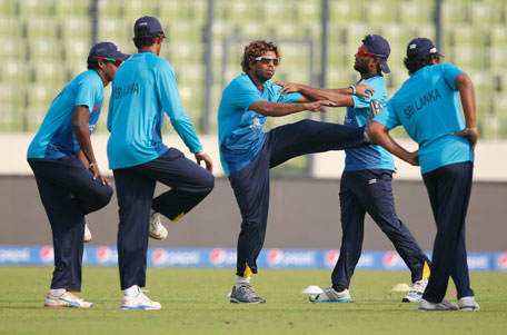 Sri Lanka's Lasith Malinga (centre) performs stretching exercises with teammates during a training session ahead of their ICC Twenty20 Cricket World Cup semi-final match against West Indies' in Dhaka, Bangladesh, Wednesday, April 2, 2014. (AP)
