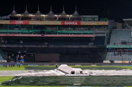 Groundsmen cover the ground as rain stops the semi-final match between Sri Lanka and West Indies in the ICC Twenty20 World Cup at the Sher-E-Bangla National Cricket Stadium in Dhaka April 3, 2014. (REUTERS)