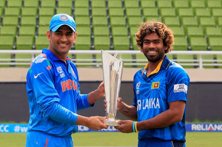 India's captain MS Dhoni (left) and Sri Lanka's Lasith Malinga pose with the trophy of ICC Twenty20 World Cup at the Sher-E-Bangla National Cricket Stadium in Dhaka April 5, 2014. (REUTERS)
