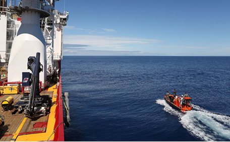 A handout photo taken on April 7, 2014 and released on April 8 by Australian Defence shows a fast response craft manned by members of ADV Ocean Shield's crew and Navy personnel pass by the starboard side of the ship as the boat searches the ocean for debris from missing Malaysia Airlines Flight MH 370 in the southern Indian Ocean. The hunt for underwater signals from missing Flight MH370 is likely to continue for days before a robot submersible is deployed to comb the seabed, the Australian search chief said on April 8, 2014. (File)