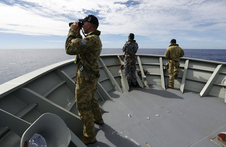 Gunner Richard Brown (L) of Transit Security Element on the lookout on the forecastle of HMAS Perth in the search for missing Malaysia Airlines flight MH370 in the southern Indian Ocean.  Two fresh signals have been picked up Australian ship Ocean Shield in the search for missing Malaysian flight MH370, raising hopes that wreckage will be found within days even as black box batteries start to expire. (AFP)