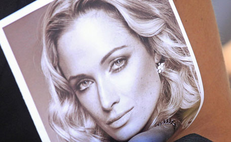 File: In this Tuesday, Feb. 19, 2013 file photo a mourner holds a program with a photo of Reeva Steenkamp at her funeral in Port Elizabeth, South Africa.  A sobbing Oscar Pistorius refused to look at a photo of her bloodied head wounds while testifying at his murder trial Wednesday, April 9, 2014, turning away from the gruesome image as the prosecutor urged the star athlete to &ldquo;take responsibility&rdquo; for killing her. (AP)