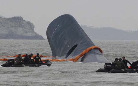 South Korean Coast Guard officers search for missing passengers aboard a sunken ferry in the waters off the southern coast near Jindo, South Korea. (AP)