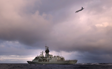A handout photo taken on April 13, 2014, and obtained on April 17, 2014, shows HMAS Perth transiting through the Southern Indian Ocean as an Orion P-3K of the Royal New Zealand Air Force searches for debris for missing Malaysia Airlines flight MH 370 in the southern Indian Ocean. The mini-submarine hunting for flight MH370 will finish scouring its current strip of the Indian Ocean within a week, Australian Prime Minister Tony Abbott has said, adding that if unsuccessful the operation will be forced to move into a new phase. (AFP)