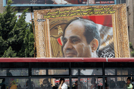 Commuters ride a bus in front of a huge banner for Egypt's former army chief Field Marshal Abdel Fattah al-Sisi in downtown Cairo, May 6, 2014. Egyptian presidential frontrunner Abdel Fattah al-Sisi on Monday appeared to rule out reconciliation with the Muslim Brotherhood movement, raising the spectre of a prolonged conflict with a group he said was finished. (REUTERS)
