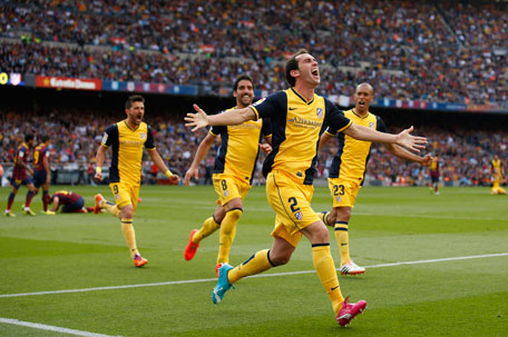 Atletico Madrid's Diego Godin (front) celebrates after scoring against Barcelona during their Spanish First Division soccer match at Camp Nou stadium in Barcelona May 17, 2014. (REUTERS)