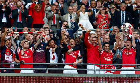 Arsenal's Thomas Vermaelen (right) lifts the trophy as he celebrates with team mates after winning their FA Cup final against Hull City, at Wembley Stadium in London, May 17, 2014. (REUTERS)