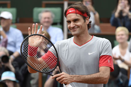 Switzerland's Roger Federer waves at the crowd after winning his French tennis Open first round match at the Roland Garros stadium in Paris on May 25, 2014. (AFP)